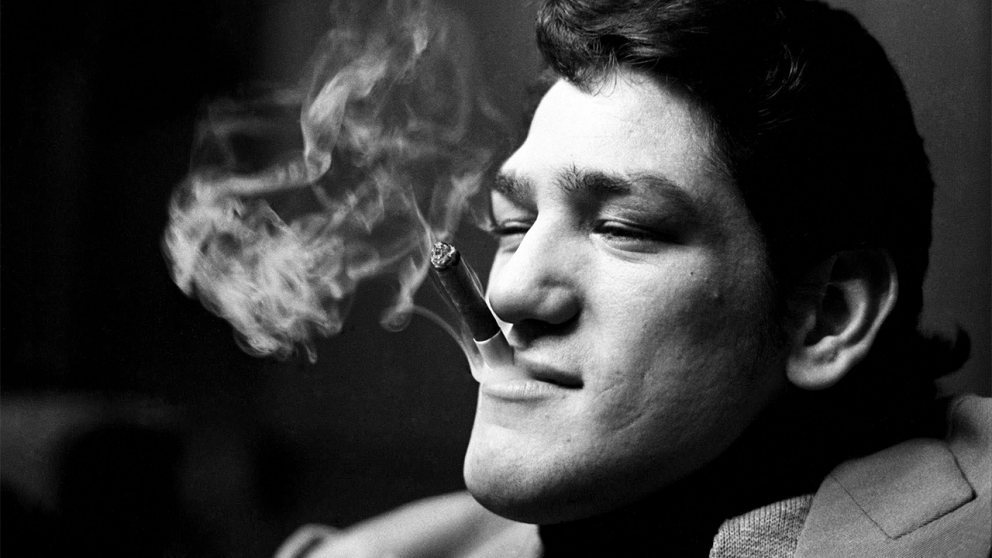 Un primer plano ic�nico en blanco y negro de �scar “Ringo” Bonavena, fumando un cigarro con una expresi�n de confianza y carisma.
